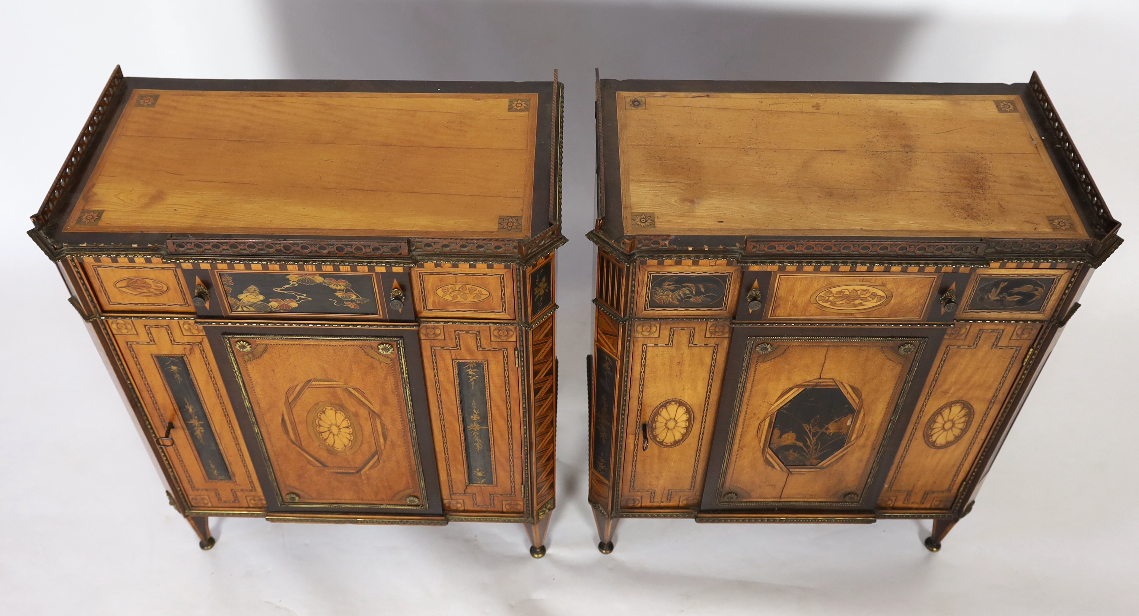 A pair of French Transitional style satinwood and marquetry side cabinets, 57cm wide, 40cm deep, 87cm high